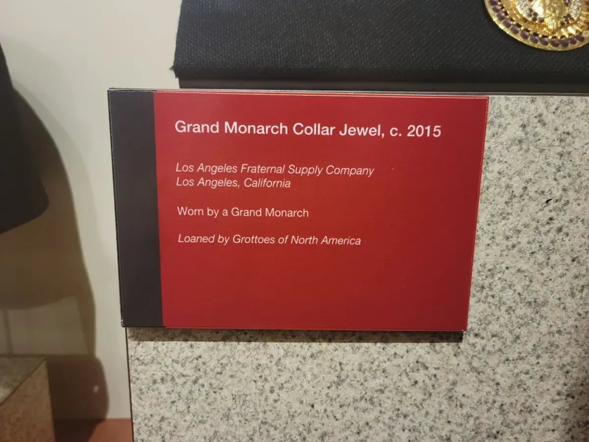 фотография музейной подписи к экспонату Grand Monarch Collar Jewel с текстом на английском языке фотография музейной подписи к экспонату Grand Monarch Collar Jewel с текстом на английском языке